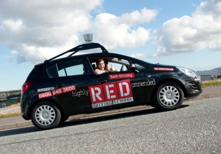 man driving RED black car