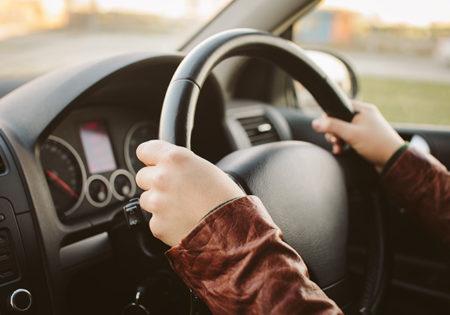 Person holding steering wheel