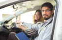 instructor and learner in car smiling at camera