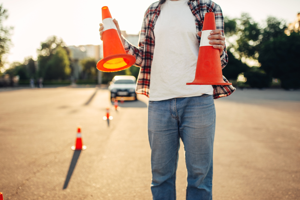 Man holding two road cones