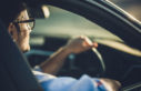 Man with glasses driving car