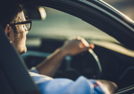 Man with glasses driving car