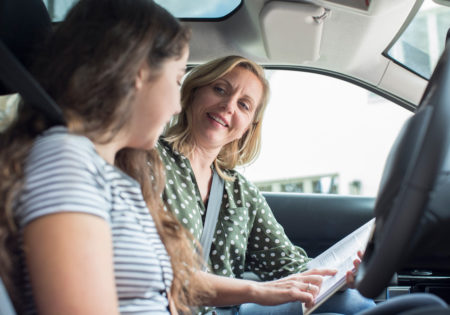 Driving instructor with learner in car