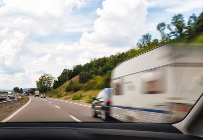 Overtake a car caravan trailer on swiss autobahn highway