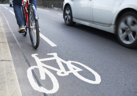 Man riding bicycle in cycle lane