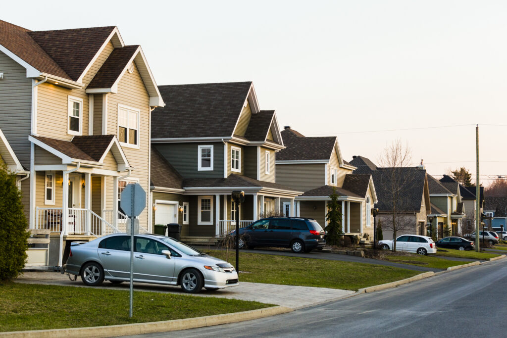 Line of suburb homes each with a car parked in the driveway