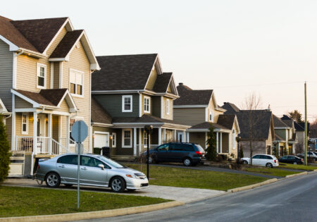Line of suburb homes each with a car parked in the driveway