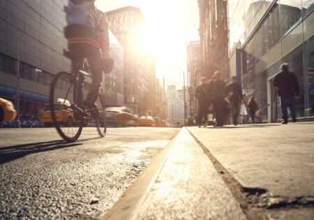 Busy street with pedestrians, taxis and a cyclist