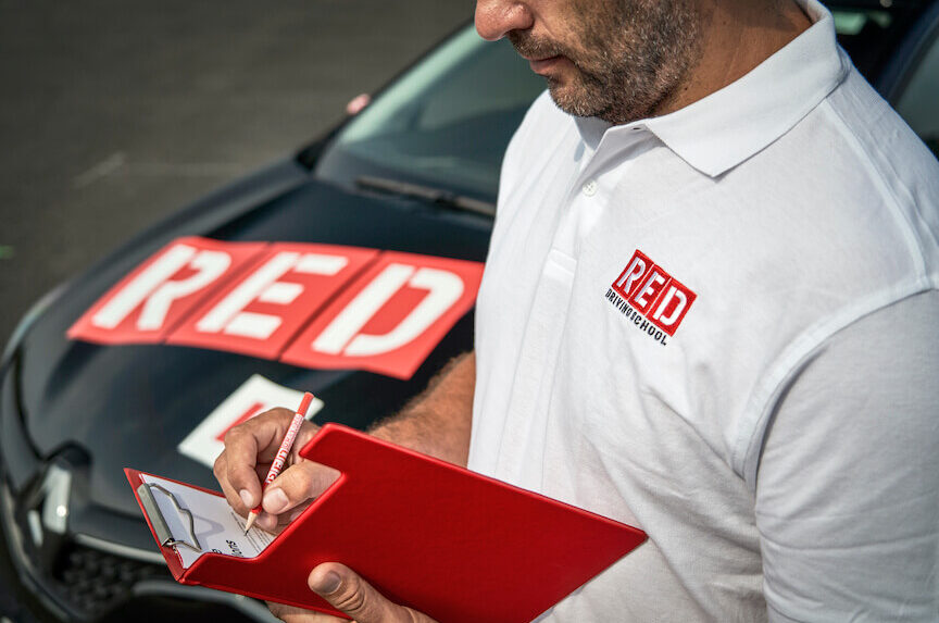 Driving instructor writing on clipboard